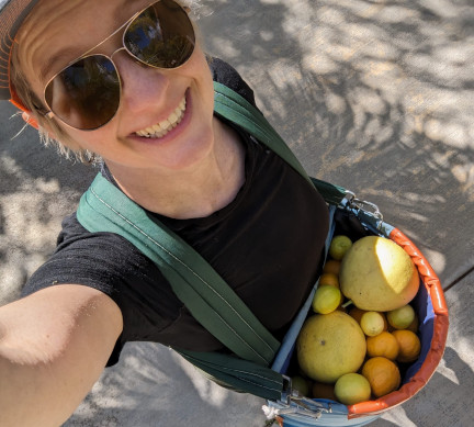 Sonnet Jonker with a fruit picker's basket in sunny California.