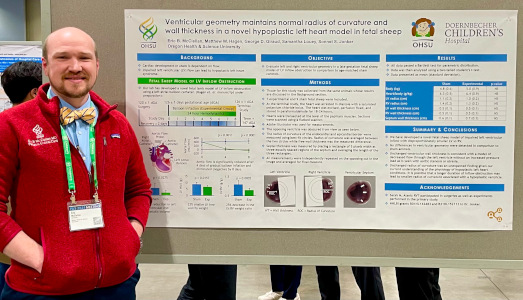Eric McClellan standing with his PAS 2024 poster.